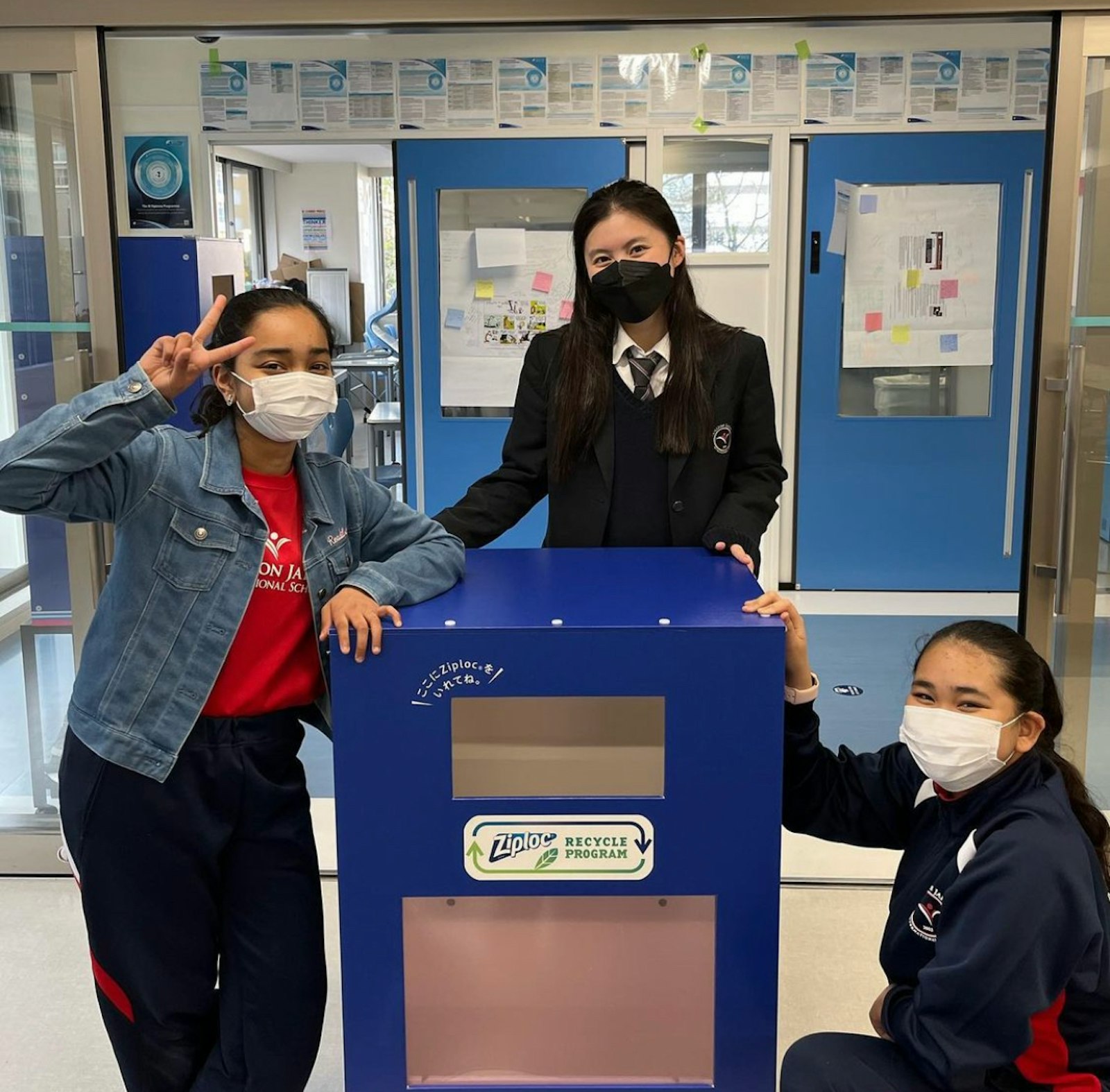 Three Climate Leaders Fellows with the recycling collection box from their school project